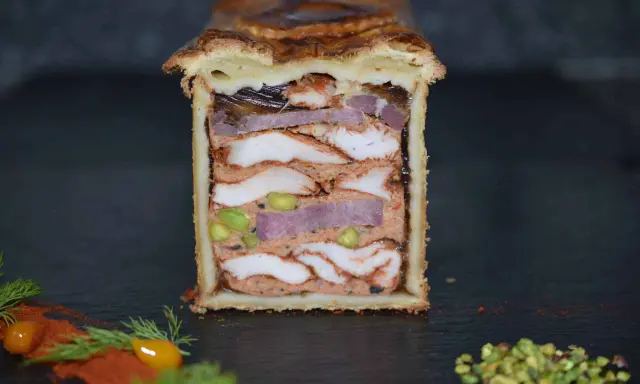 Pâté en croûte aux multiples couches de viandes, pistaches et gelée. Une œuvre d'art culinaire digne de la recette du meilleur pâté en croûte du monde.