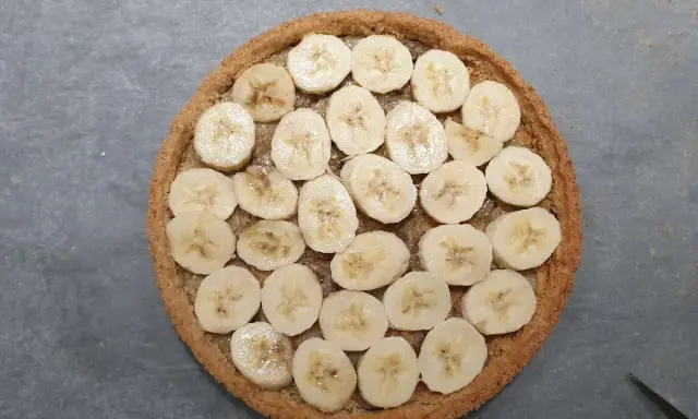 Tarte banoffee origine : rondelle de bananes sur une pâte sablée, prête à être dégustée.