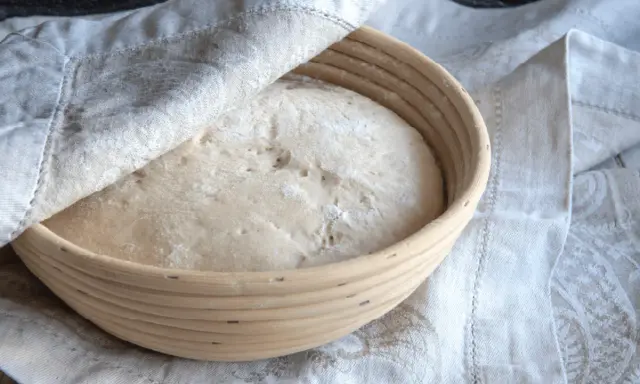 Pâte à pain dans un banneton, prête à lever. Trop de levure dans le pain peut entraîner des conséquences indésirables sur la texture et le goût.