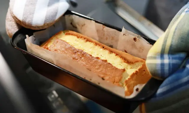 Un gâteau doré sort du four, sa pâte à gâteau parfaitement cuite dans son moule.