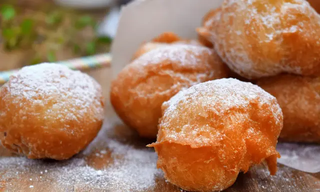 Des pets de none dorés et saupoudrés de sucre glace, prêts à être dégustés. Un délice croustillant et moelleux.
