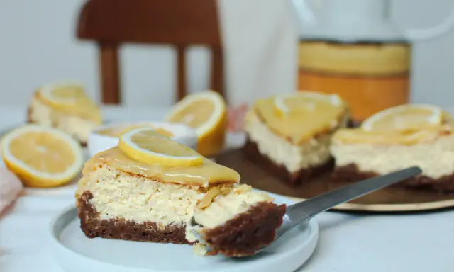 Tranches de cheesecake citron, garnies de rondelles de citron frais, sur une assiette blanche.