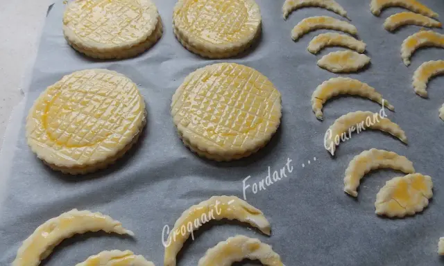 Sur une plaque, des disques de pâte feuilletée prêts à cuire, certains en forme de croissant, pour une délicieuse croute vol au vent.
