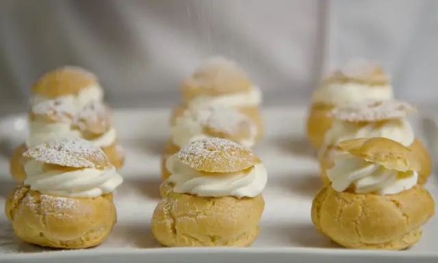 Petits choux garnis de crème fouettée, saupoudrés de sucre glace. La cuisson des choux est parfaite, dorée et légère.