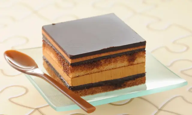 Un délicieux gâteau Opéra, une recette facile à réaliser, avec ses couches de biscuit, de crème au café et de ganache au chocolat.