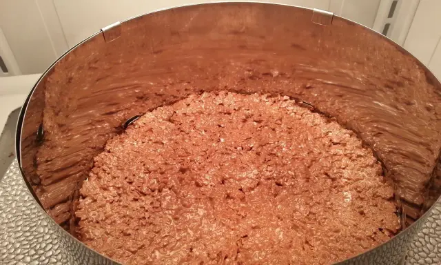 Fond de gâteau croustillant sans cuisson, une texture gourmande de chocolat et de riz soufflé dans un cercle à pâtisserie.
