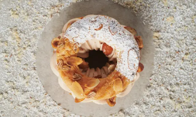 Un Paris-Brest aérien, garni d'une crème onctueuse et décoré d'amandes effilées. Le praliné pour Paris-Brest est ici sublimé.