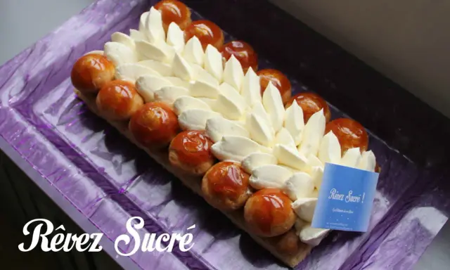 Un déliceux saint honoré rectangulaire, orné de crème onctueuse et de profiteroles caramélisées, prêt à être dégusté.