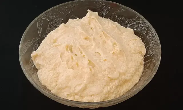 Crème d'amande onctueuse dans un bol en verre texturé, prête à être dégustée.