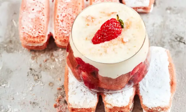 Un délicieux tiramisu aux biscuits roses de Reims, garni de fraises et de crème onctueuse, sur un lit de biscuits saupoudrés de sucre glace.