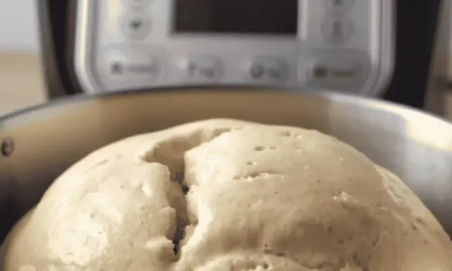 Pâte à pain gonflée dans un bol, prête pour le temps de pétrissage du pain au robot.