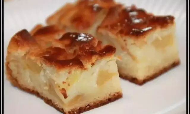 Trois parts de gâteau moelleux sans oeuf aux pommes, saupoudrées de sucre glace, sur une assiette blanche.
