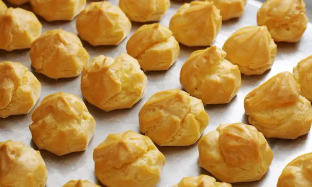 Une fournée de **meilleur choux à la crème** dorés et prêts à être garnir. Parfait pour un dessert gourmand.