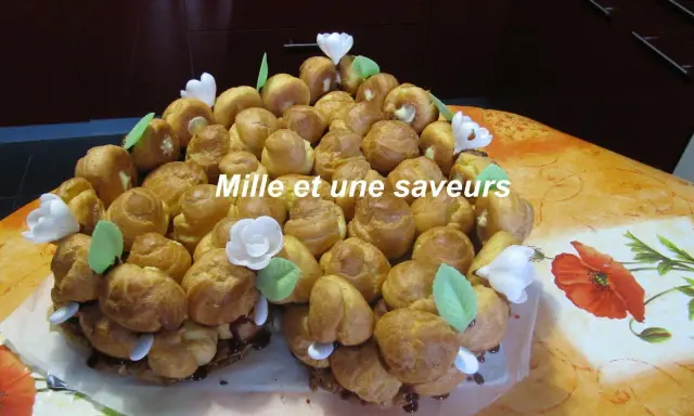 Magnifique chou pièce montée, un délice pour les yeux et les papilles, ornée de fleurs blanches et de feuilles vertes.