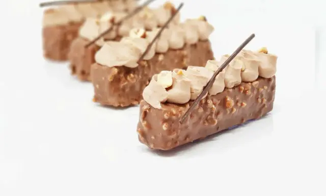 Délicieux entremets chocolat praliné, recouverts de noisettes croquantes et surmontés d'une crème onctueuse.