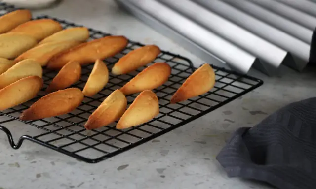 Biscuits dorés en forme de dent de loup refroidissent sur une grille.