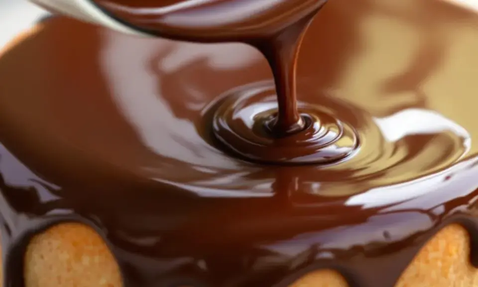 Un glaçage chocolat caramel coule sur un gâteau. La texture lisse et brillante promet un délice gourmand.