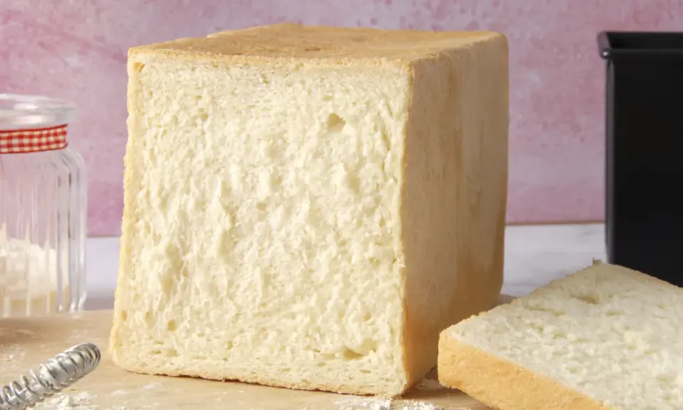 Un pain de mie parfait, tout juste sorti du four. La cuisson du pain de mie est une étape clé pour obtenir cette mie aérée et cette croûte dorée.