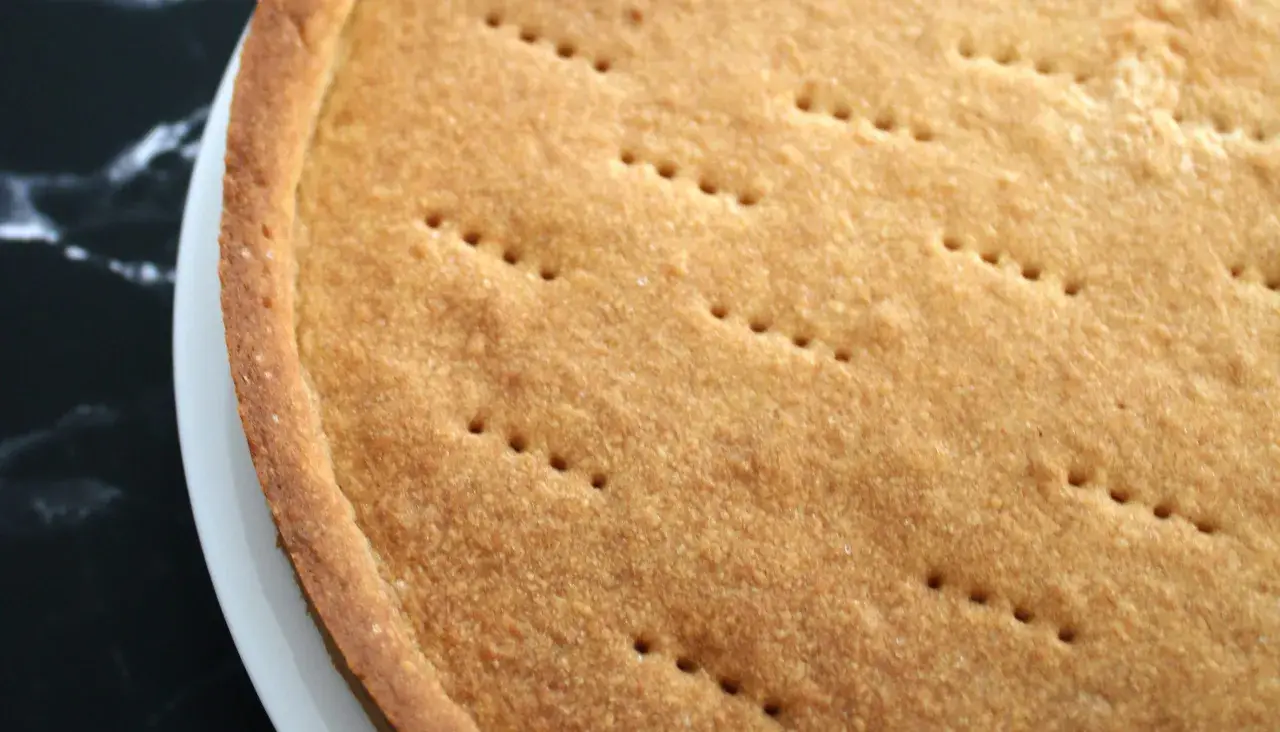 Pâte sucrée dorée, prête pour une recette rapide. Les petits trous indiquent qu'elle est prête à être garnie.