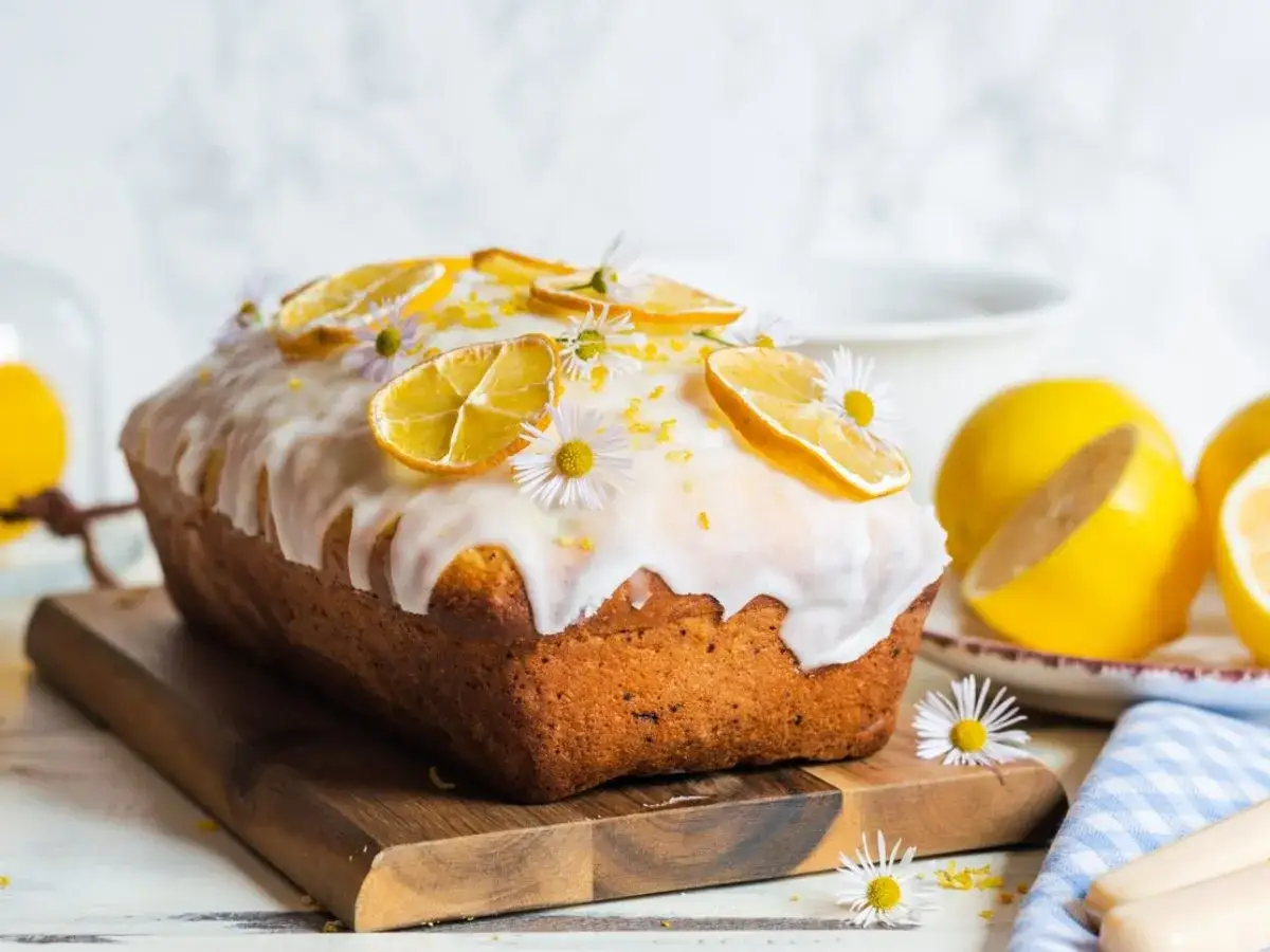 Un délicieux cake citron, glacé et décoré de fines tranches de citron séché et de petites fleurs. Parfait pour une recette facile et gourmande.