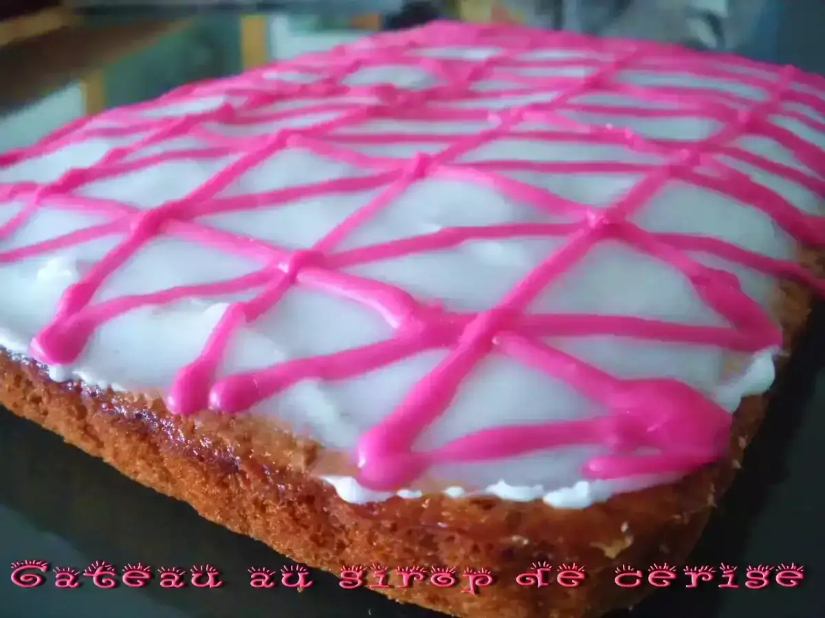 Gâteau rectangulaire avec glaçage blanc et décorations roses en zigzag. Un délice au sirop à 30, parfait pour le goûter.