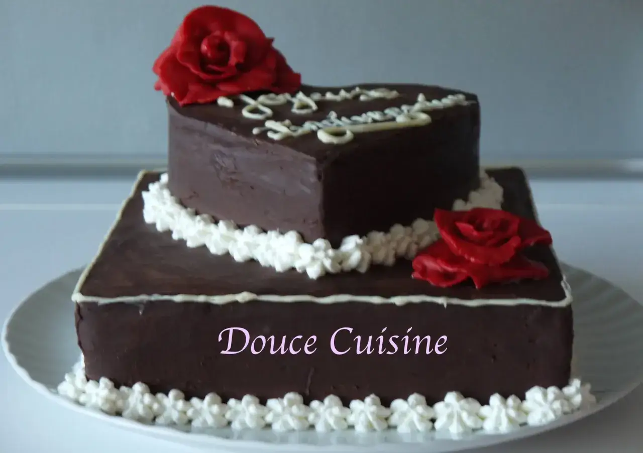 Gâteau à deux étages en chocolat, décoré de roses rouges et de crème. Une inspiration pour une recette opéra conticini.