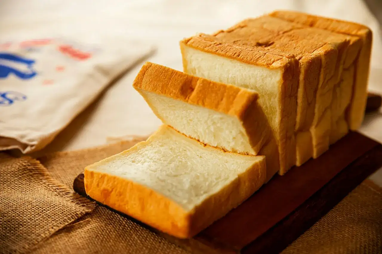 Tranches de pain de mie dorées, parfaites pour réussir son pain. Une texture moelleuse et une croûte appétissante.