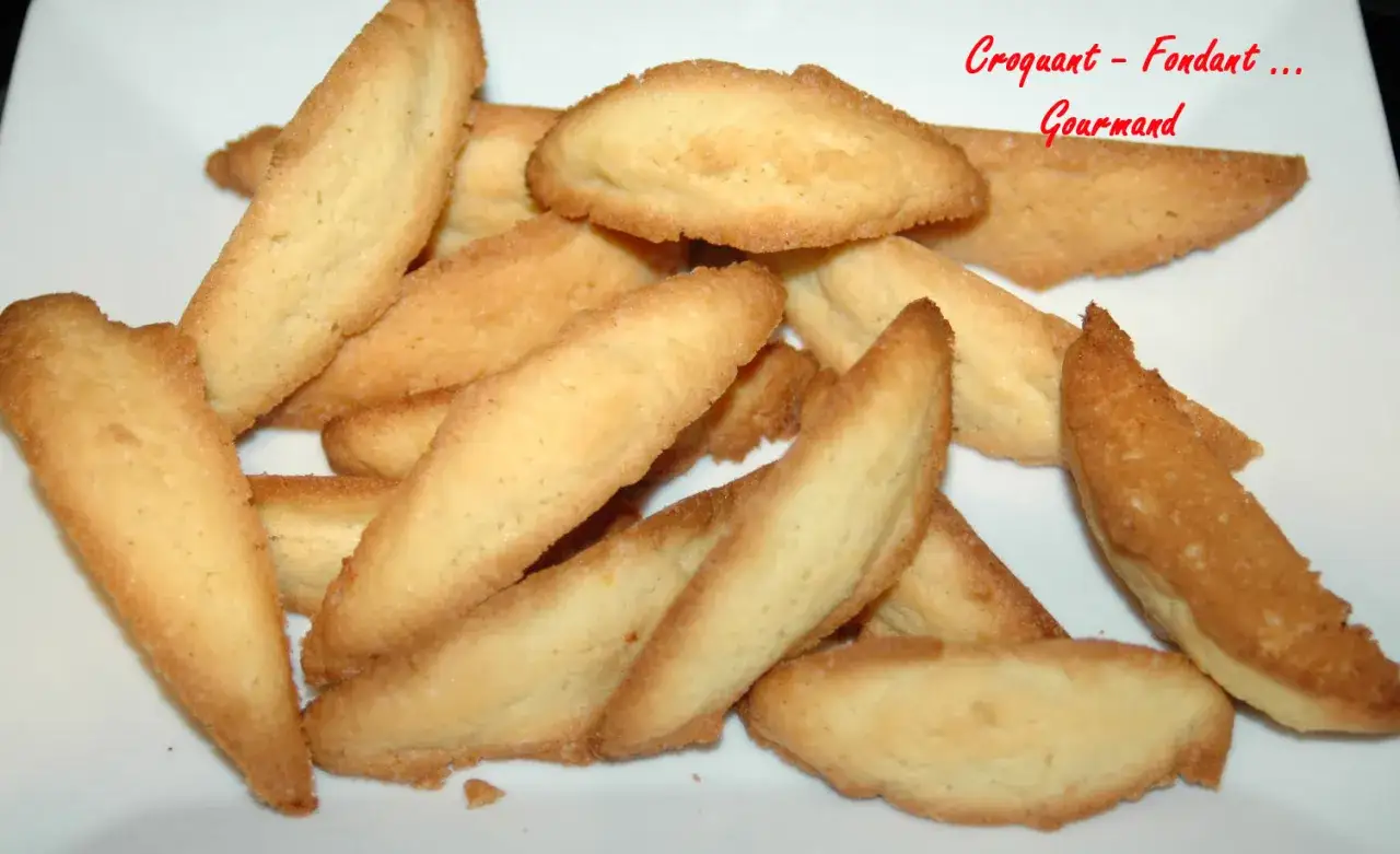 Une pile de biscuits dorés, ressemblant à des dents de loup, prêts à être dégustés. Parfaits pour une recette gourmande.