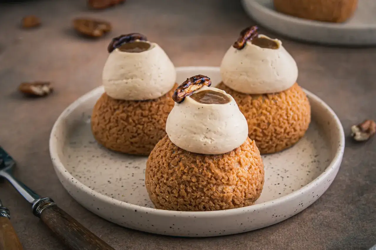 Trois choux à la crème, couronnés de crème onctueuse et d'une noix caramélisée, promettent le meilleur choux à la crème.