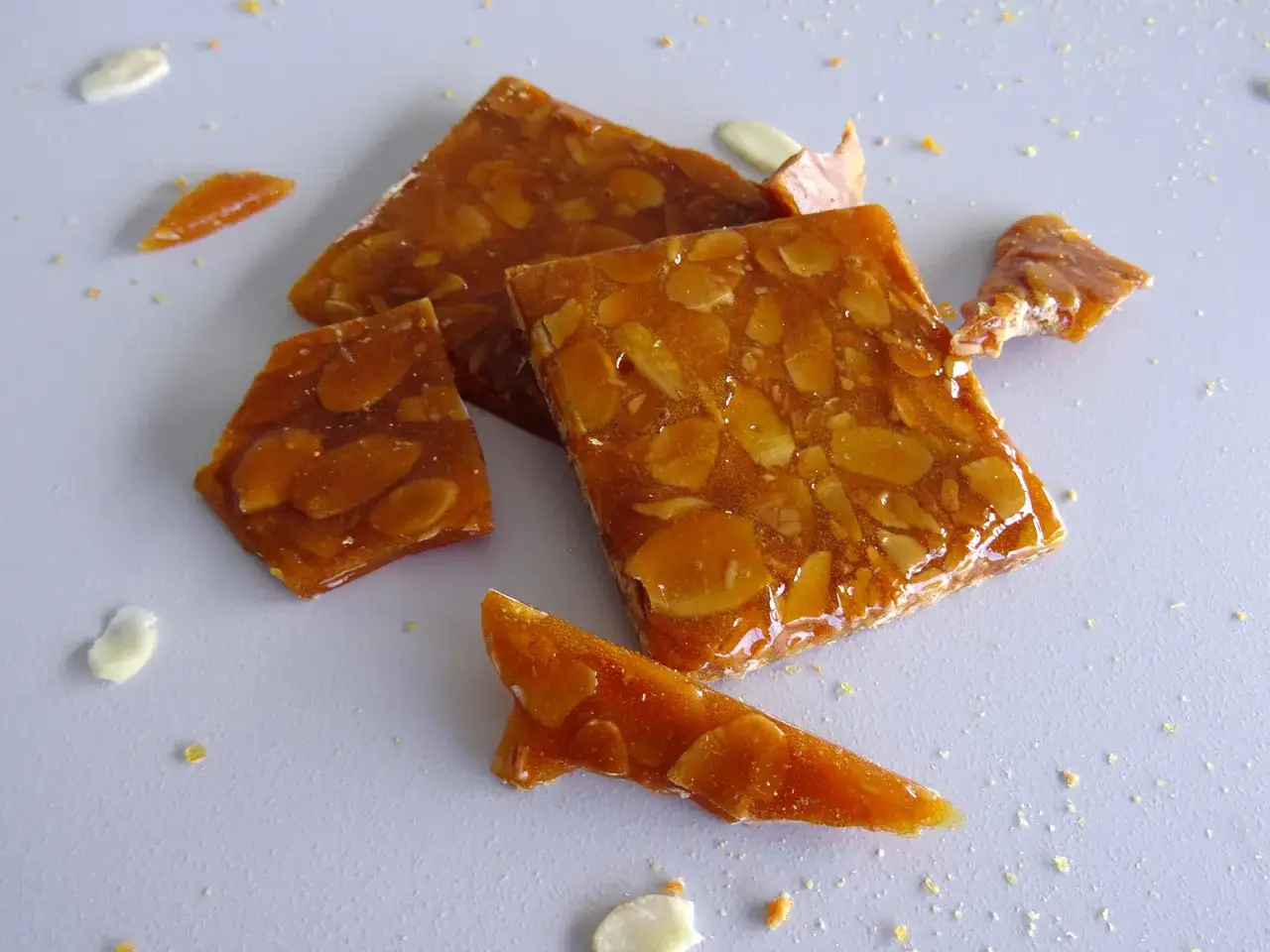 Des morceaux de nougatine craquante aux amandes, un délice doré et croquant.