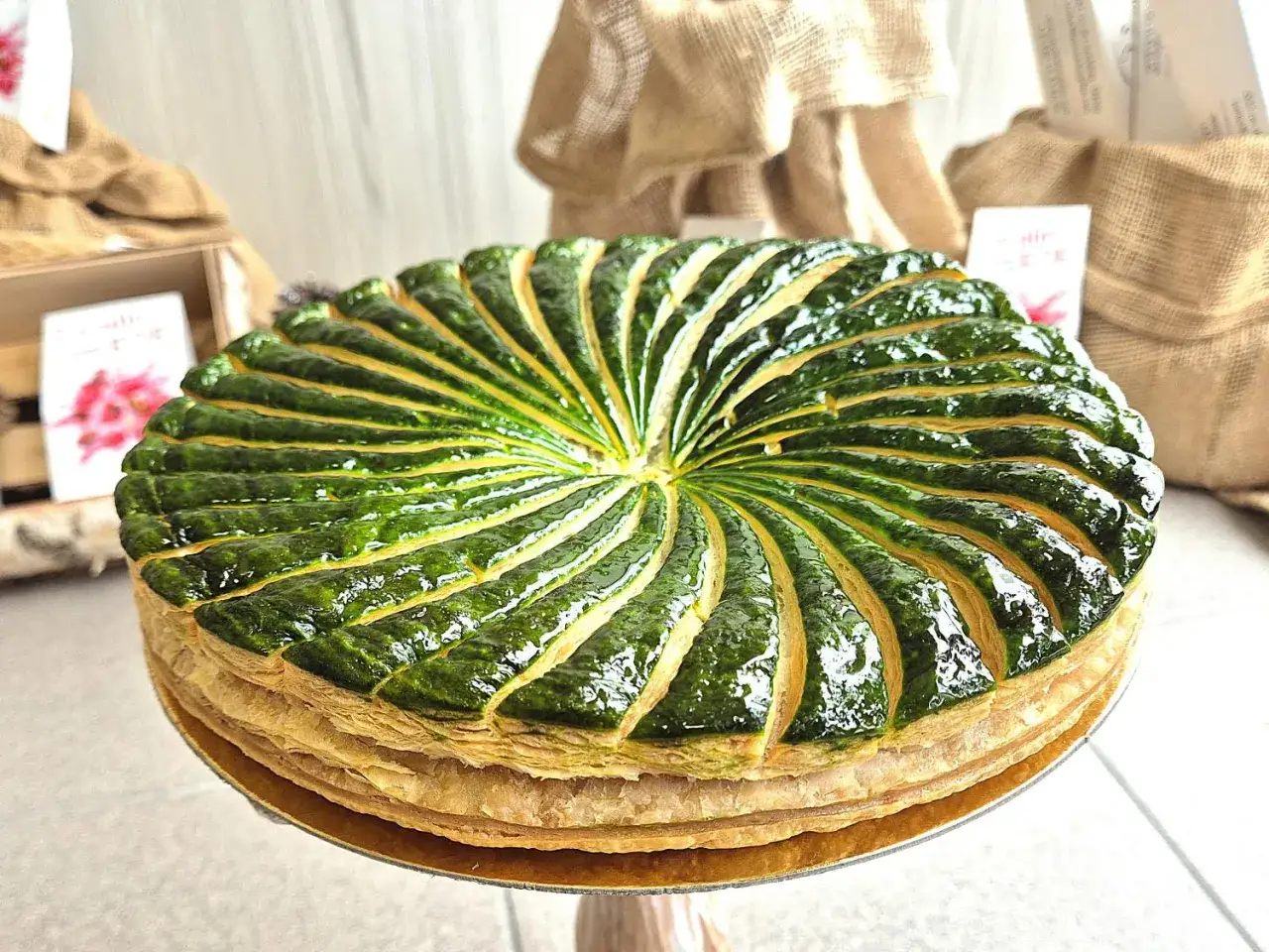 Une magnifique galette pistache framboise, aux feuilles vertes brillantes, prête à être dégustée.