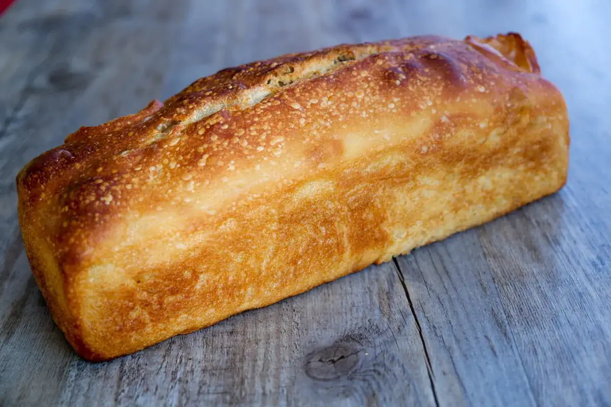Pain poolish doré, prêt pour la cuisson du lendemain. Sa croûte craquante promet un délice.
