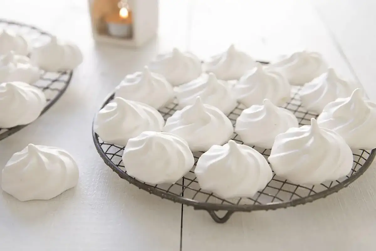 Douces meringues blanches, prêtes pour la cuisson, sur une grille.