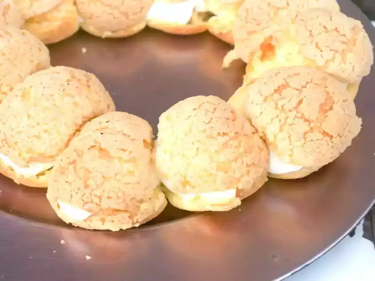 Un Paris-Brest, un délice de pâte à choux garni de crème, forme un cercle gourmand sur une assiette.