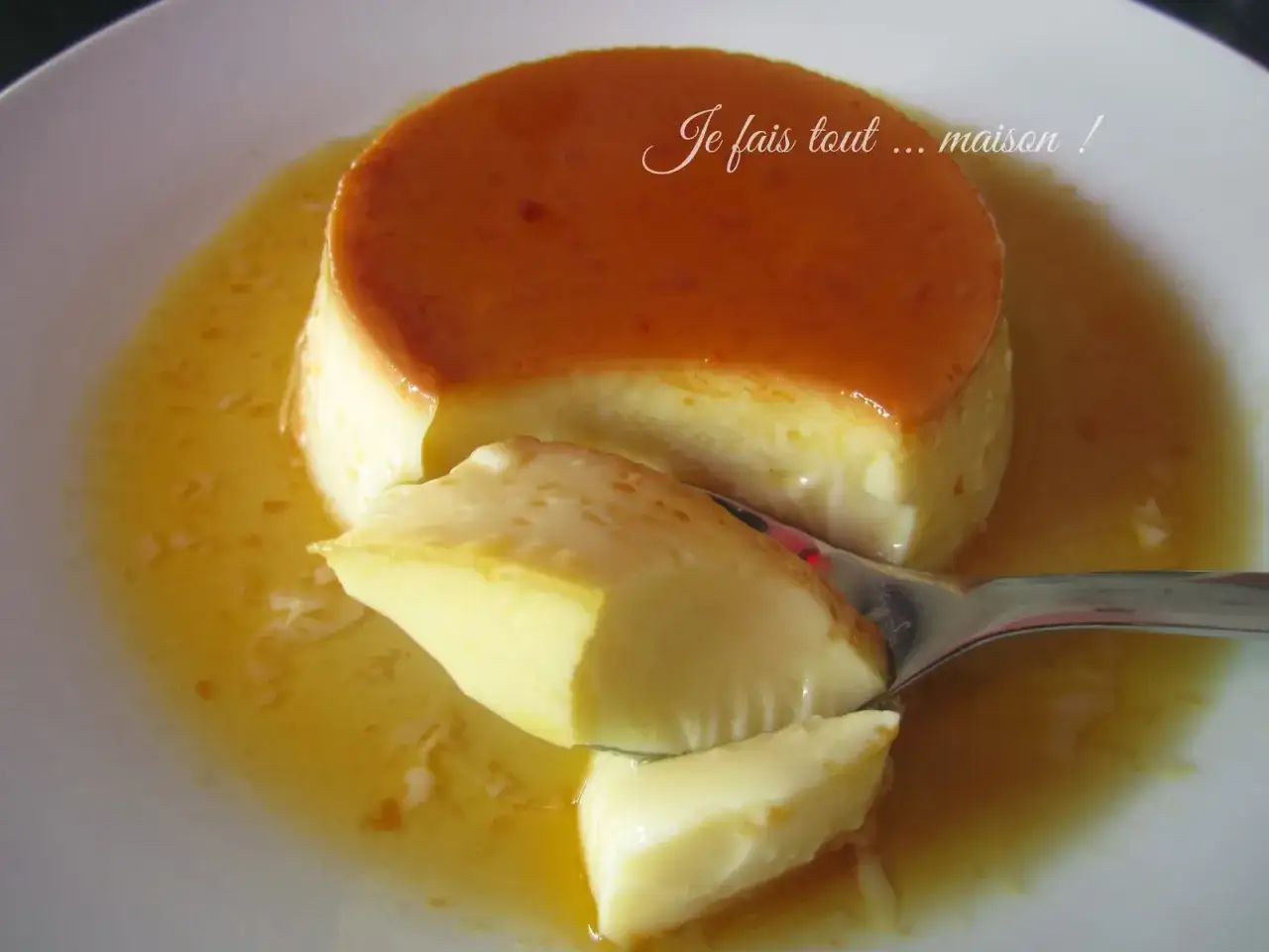 Une cuill&egrave;re pr&eacute;l&egrave;ve un morceau d'un d&eacute;licieux cr&egrave;me renvers&eacute;e, son caramel dor&eacute; coulant.