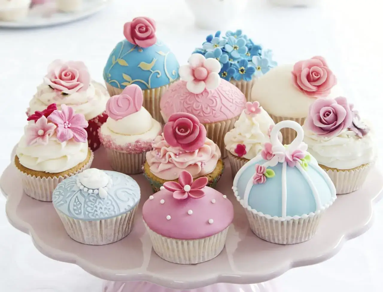 Magnifiques cupcakes décorés de pâte à sucre, parfaits pour une recette festive. Roses, fleurs bleues et cœurs en sucre.
