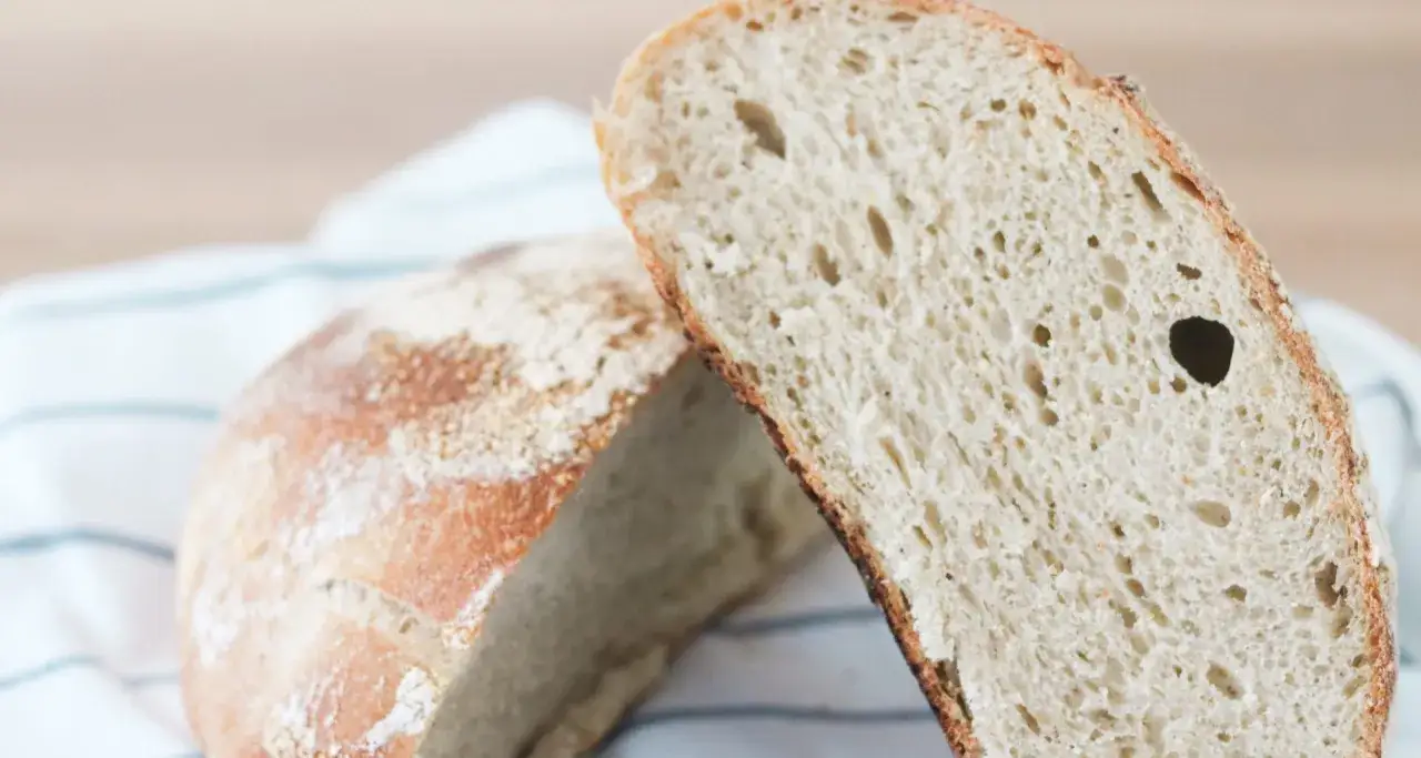 Pain de campagne coupé en deux, révélant une mie aérée et une croûte dorée. Un délice fait avec levain avec levure de boulanger.
