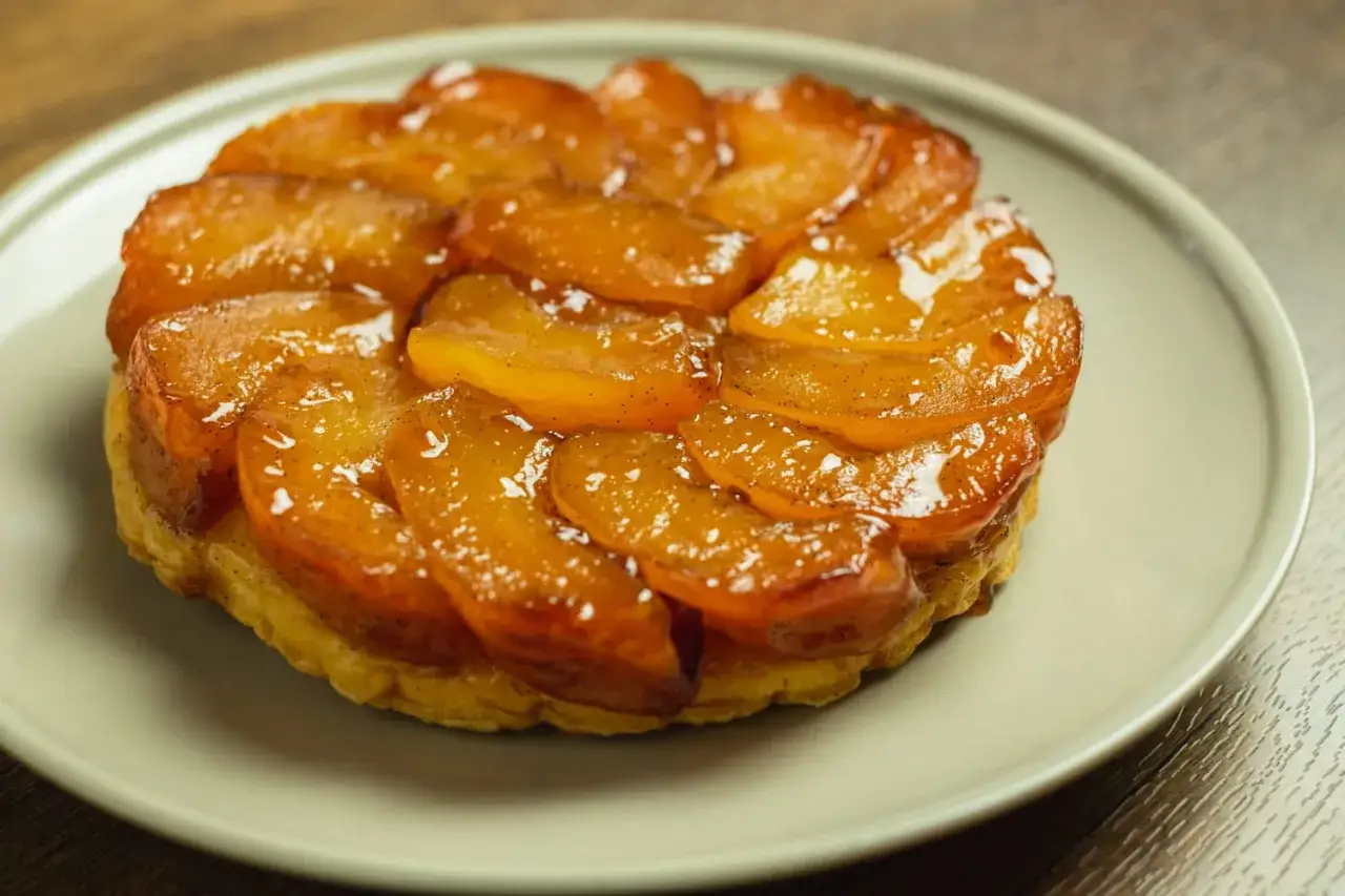 Tarte Tatin aux pommes caramélisées, prête pour la dégustation. La cuisson a révélé des fruits dorés et un caramel brillant.