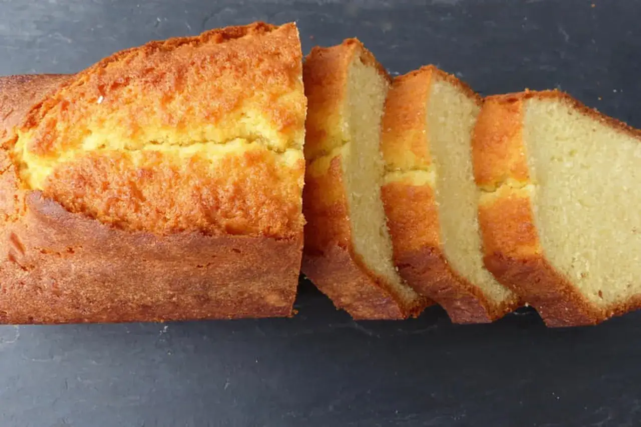 Un quatre-quarts doré et moelleux, coupé en tranches. La meilleure recette de quatre-quarts pour un goûter parfait.