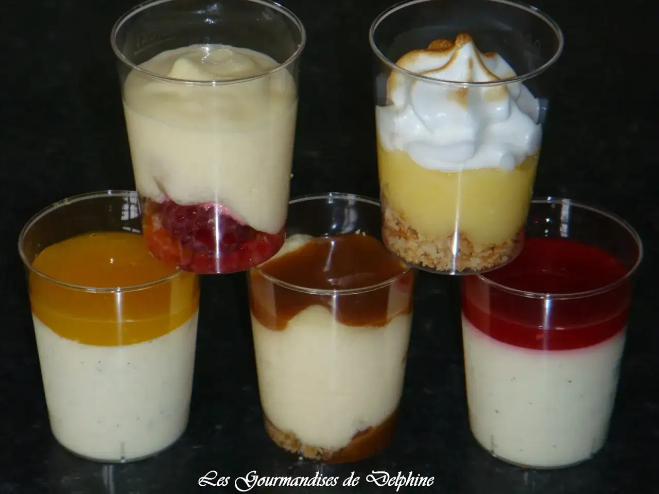 Cinq verrines gourmandes : panna cotta coulis framboise, citron meringu&eacute;, caramel, mangue et fruits rouges.