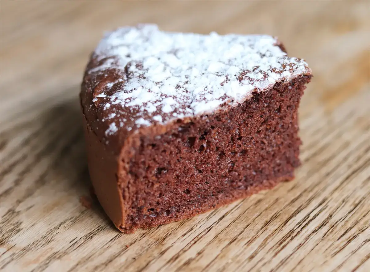 Tranche de gâteau au chocolat, saupoudrée de sucre glace. Une délicieuse recette gâteau crème fraîche chocolat.