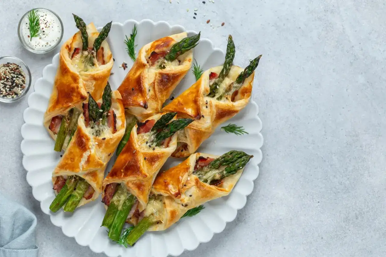 Délicieux feuilleté aux asperges, enroulé dans une pâte dorée avec du bacon et du fromage. Parfait pour un apéritif !