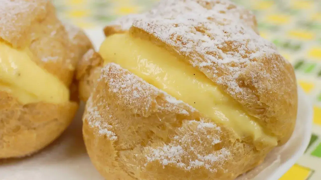Deux choux à la crème généreusement garnis de crème pâtissière onctueuse, saupoudrés de sucre glace.