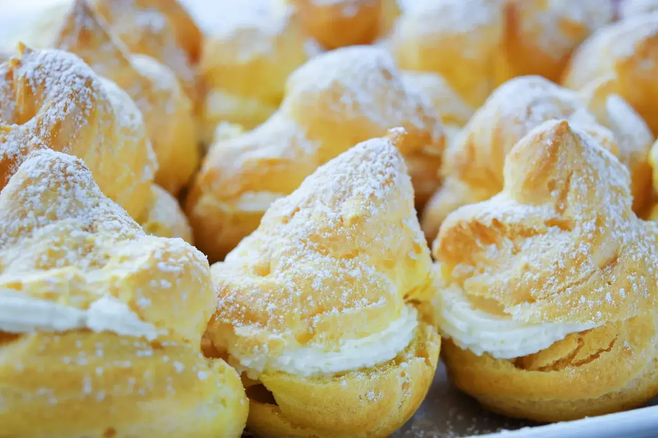Des profiteroles de pâte à choux, garnis de crème et saupoudrés de sucre glace. Un délice gourmand !