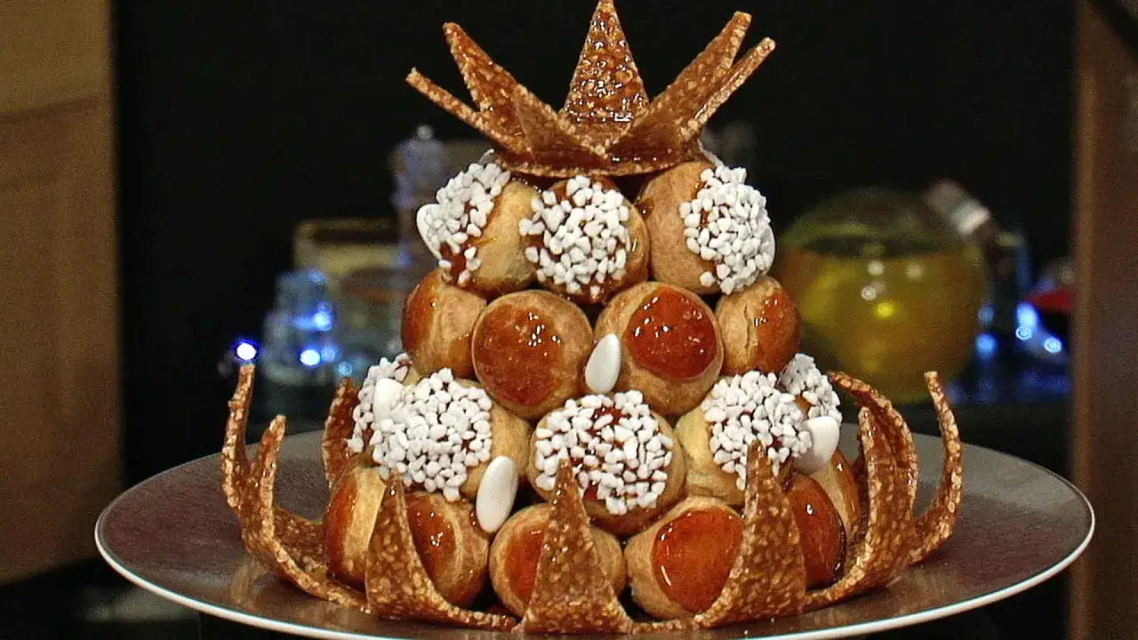 Magnifique pièce montée en choux garnis, décorée de perles de sucre et d'un caramel croquant en forme de couronne.