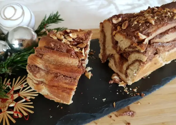 Délicieuse babka recette, un gâteau tressé au chocolat et noisettes, orné de décorations de Noël.