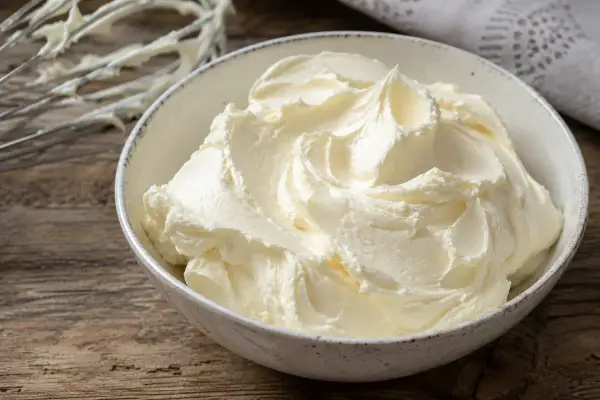 Un bol rempli de crème au beurre professionnelle, onctueuse et aérienne, prête à être utilisée pour des décorations pâtissières.