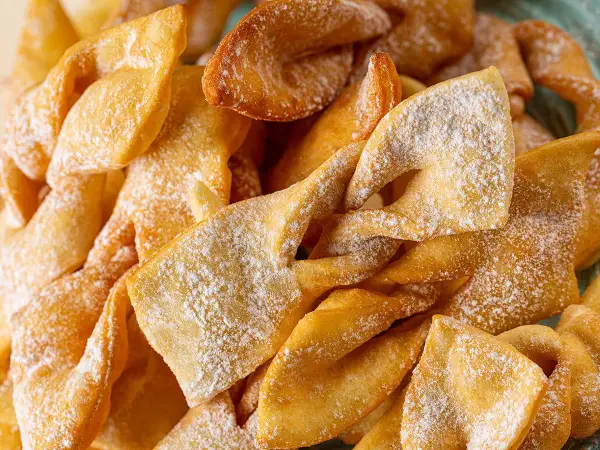 Des merveilles bien gonflées, dorées et saupoudrées de sucre glace, prêtes à être dégustées. Un délice croustillant !