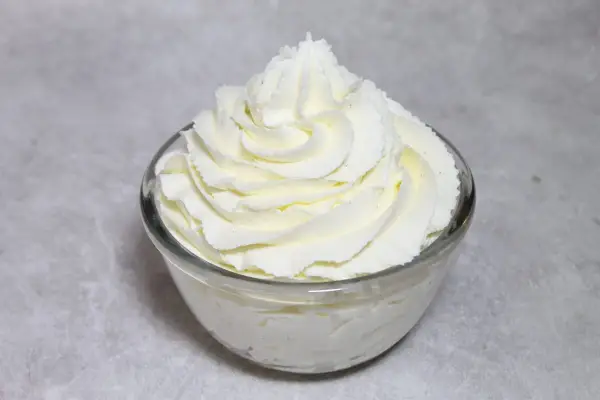 Chantilly aérienne, parfaitement montée au robot pâtissier, dans un bol en verre. Un délice pour les yeux et les papilles.