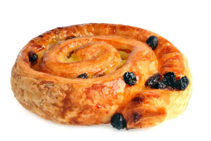 Un délicieux pain aux raisins, feuilleté et doré, parsemé de raisins secs moelleux.